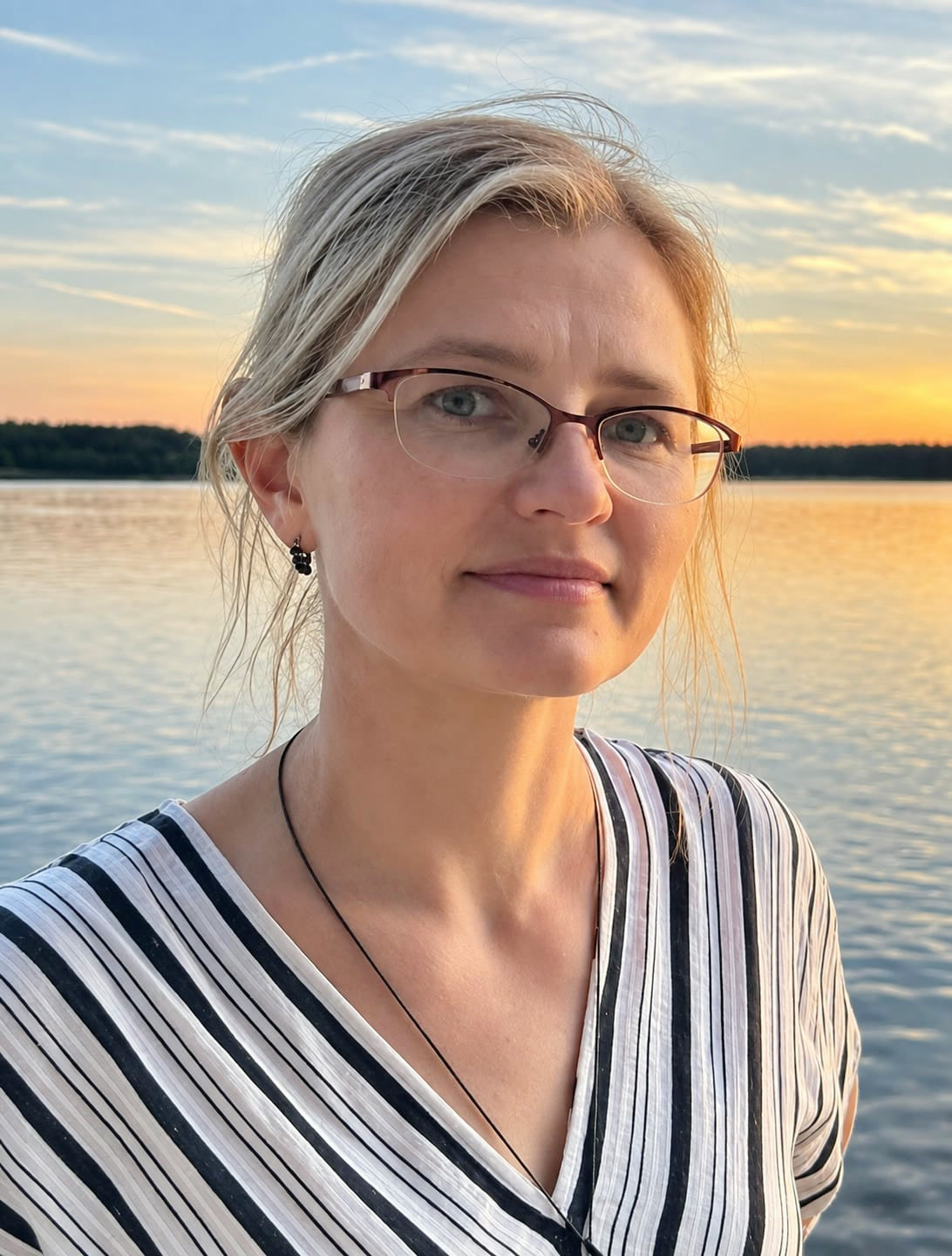 Janna, Willow Leaf massage therapist, beside a lake at sunset